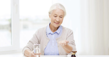 Seniorin nimmt Arzneimittel ein