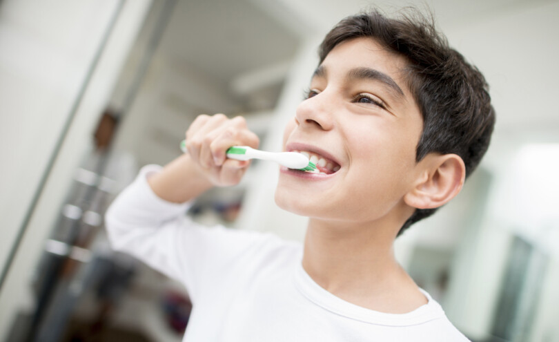 Junge putzt sich mit Zahnpasta die Zähne