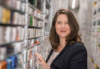 Medpex Apothekerin vor dem Regal mit Medikamenten
