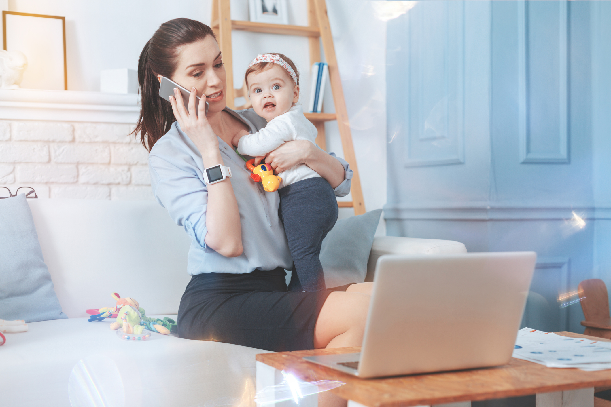 Job nach der Elternzeit - Arbeitende Mutter mit Kind auf dem Arm