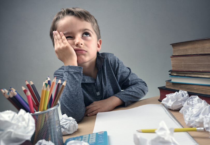 Konzentrationsstörungen bei Kindern - Junge verzweifelt an Hausaufgaben