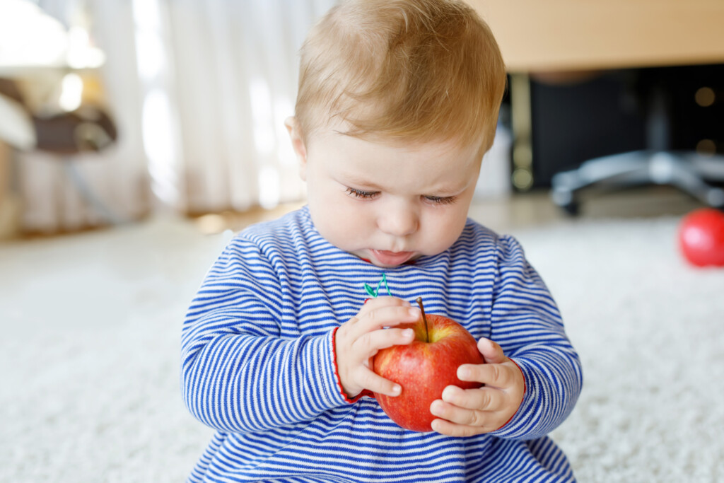 Vitamine für Kinder - Baby mit Apfel